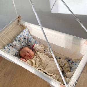 Un nourrisson dort dans un hamac bébé confort de Petite Planète.