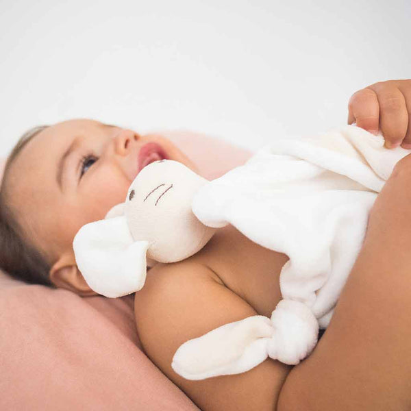 un doudou bio made in France Lili la souris dans les bras d'un bébé