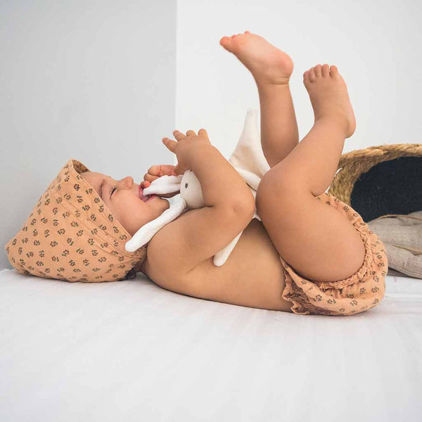 un bébé jouant avec un doudou made in france Petite Planète