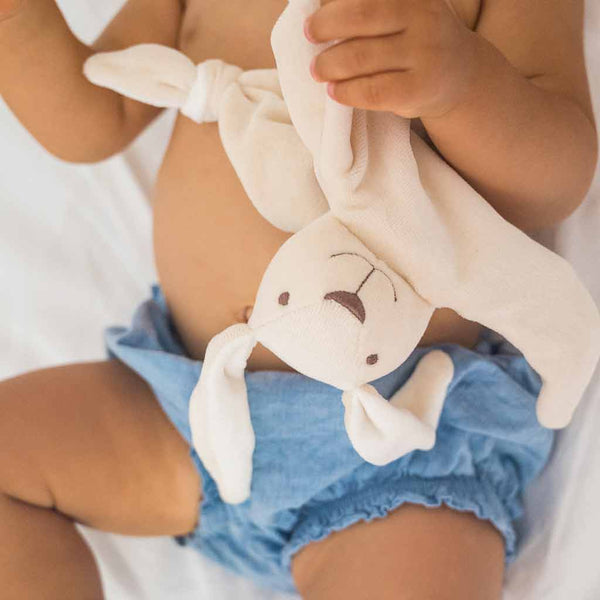 un doudou bio made in France dans la main d'un bébé
